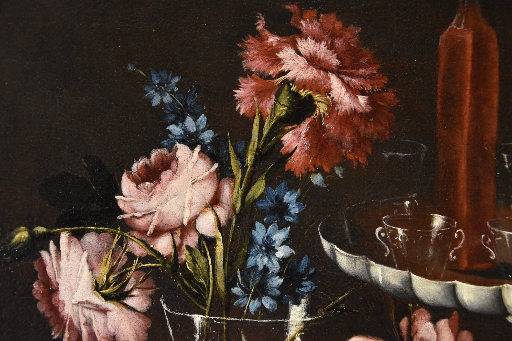 Natura morta con fiori, alzata con cristalli e liquori, porcellane e cesto con biscotti
