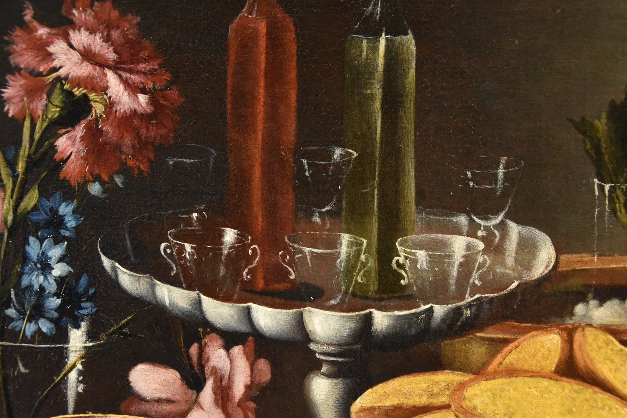 Natura morta con fiori, alzata con cristalli e liquori, porcellane e cesto con biscotti
