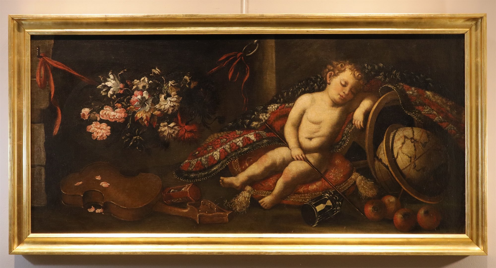 Vanitas con putto dormiente su un tappeto, fiori, violino, globo terrestre, clessidre e melograni